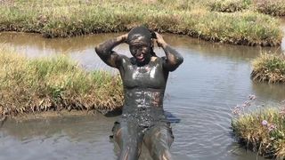 Sexy Girl playing in the River Mud. Muddy fun (Fully Clothed)